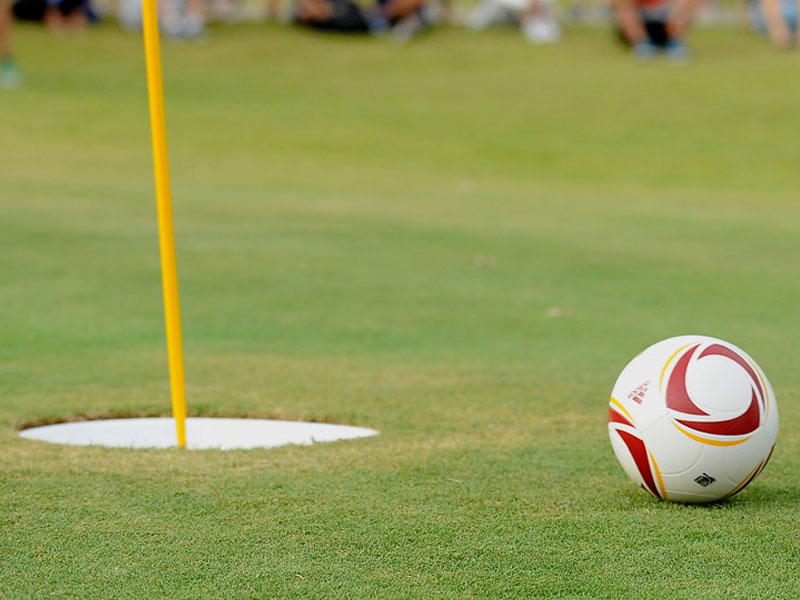 Foot Golf ball near the cup on a green at Green Tree Golf Club in Victorville, CA.