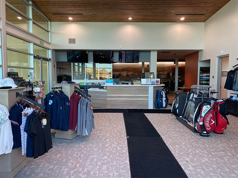 Green Tree Golf Club pro shop counter with apparel, golf bags, and accessories.